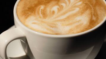 A cup of coffee with latte art on a saucer.