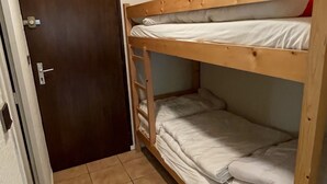 A bunk bed room with a wooden ladder, a door, and a tiled floor. - Quiet studio for 4 pers. with terrace in Samoëns (Samoëns)