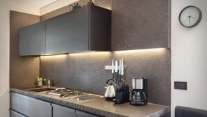 A modern kitchen with a granite countertop, stainless steel appliances, and a knife rack.