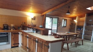 A kitchen with wooden cabinets, a central island, and a dining area with a table and chairs.
