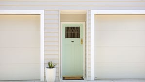 A house with a light green door, a potted plant, and a doormat. - Tea Gardens Loft - Boutique Accommodation (Tea Gardens)