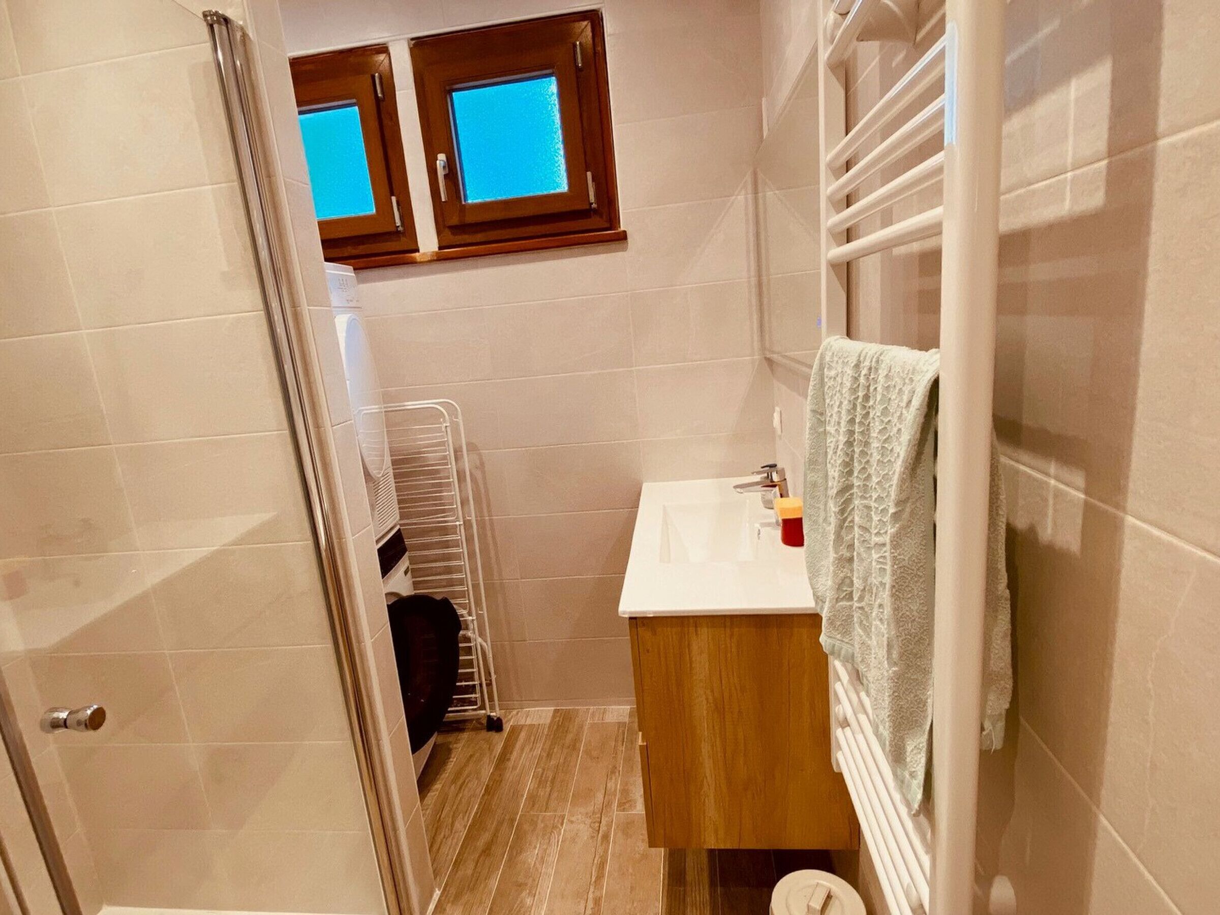 Ein Badezimmer mit einem Holzwaschtisch, einer weißen Spüle, einem Handtuchhalter und einem Fenster mit Blick.