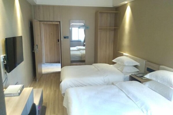 A hotel room with two beds, a TV, a desk, and a wardrobe. - Chaohu Zhongxin Business Hotel (Chaohu)