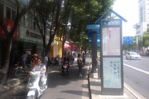 Una escena callejera con una parada de autobús, bicicletas y peatones.