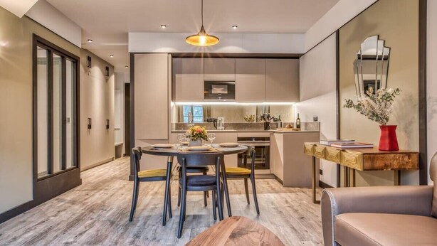 A modern interior with a dining area, kitchen, and living space. - Majestic Broadway - 4 star apartment with spectacular views (Chamonix-Mont-Blanc)