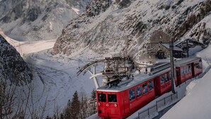 A red cable car ascending a snowy mountain slope. - Majestic Broadway - 4 star apartment with spectacular views (Chamonix-Mont-Blanc)
