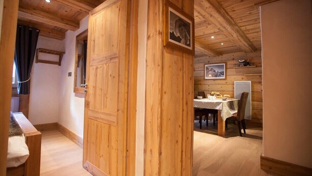 Ein Holzinterieur mit Essbereich, Tisch, Stühlen und einer Bank.