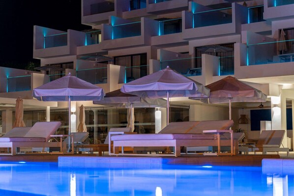 A modern hotel with a pool area, featuring lounge chairs and umbrellas. - Royal Marina Suites Boutique Hotel (Yaiza)