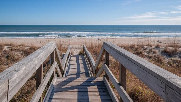A wooden boardwalk leading to a beach with a clear view of the ocean. - Fresh and Salty (Carolina Beach)