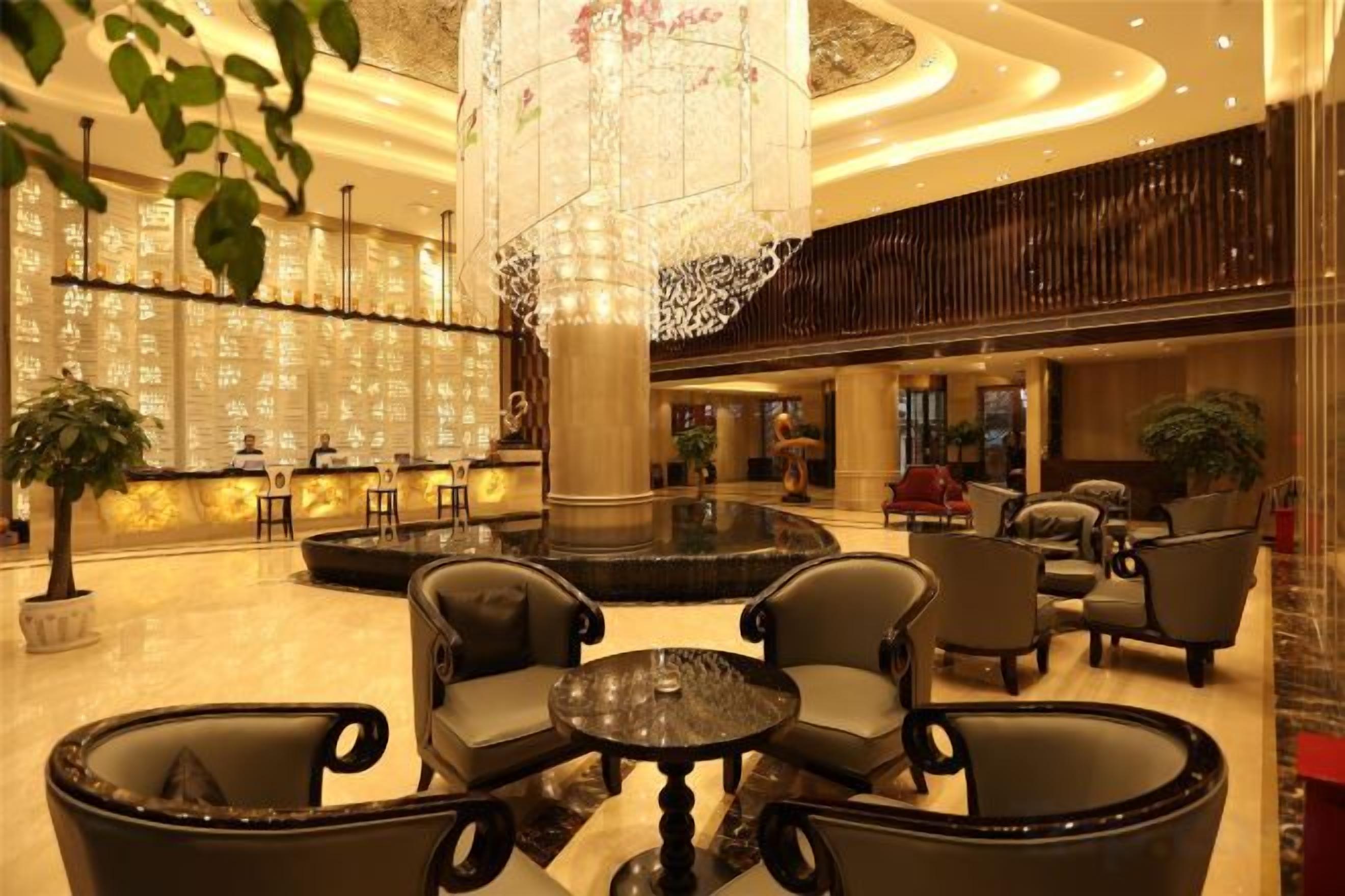 A lobby with a reception desk, seating area, and a decorative fountain.