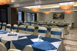 A banquet hall with round tables, chairs, and a chandelier. - Yuanlin Hotel (Tongzi County)