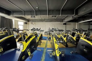 Un gimnasio con bicicletas estáticas dispuestas en filas.