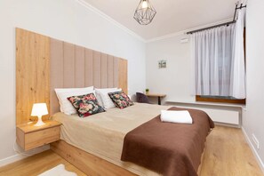 Relax in a serene bedroom with a large bed, wooden headboard, and decorative pillows.