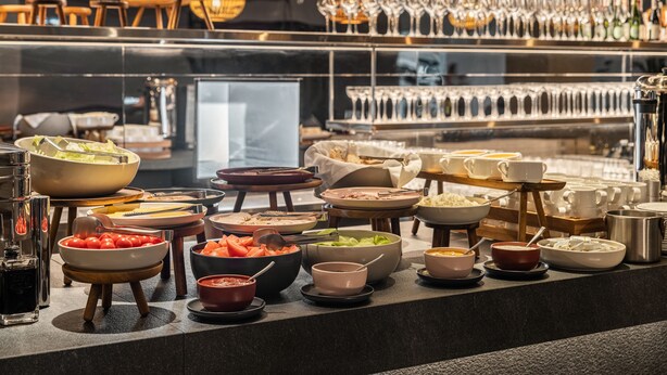 Montaje de bufé con diversos alimentos y utensilios.