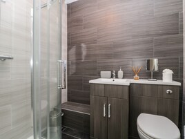 A modern bathroom with a glass shower enclosure, a sink with a mirror, and a toilet.