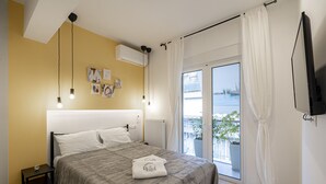 Un dormitorio con cama, mesita de noche y vistas a un balcón.