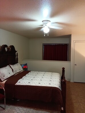 Cozy retreat with a single bed, wooden headboard, and a comfortable chair.