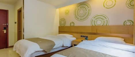 Habitación de hotel con dos camas, un cabecero de madera y una pared con diseños circulares.
