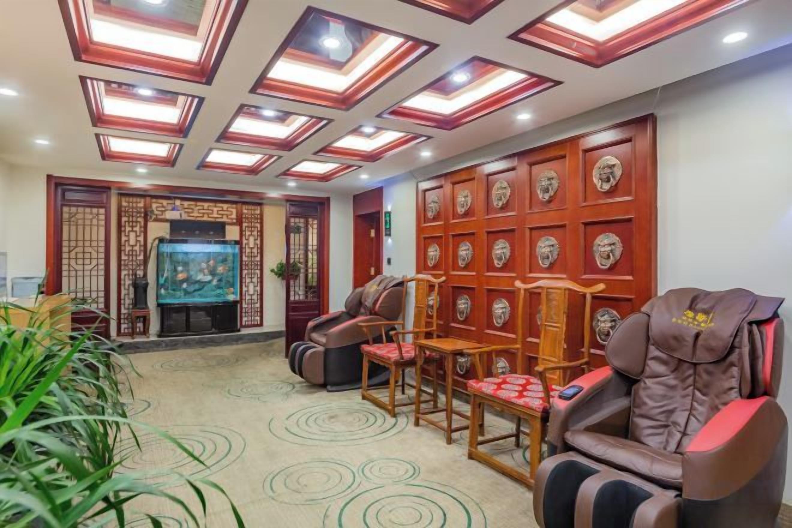 Una habitación con sillón de masajes, acuario y un muro decorativo con diseños circulares.