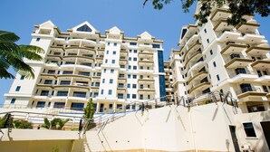 A multi-story residential building with balconies, a staircase, and a clear sky. - The Beautiful 3Br All En-suite Apt (Mombasa)
