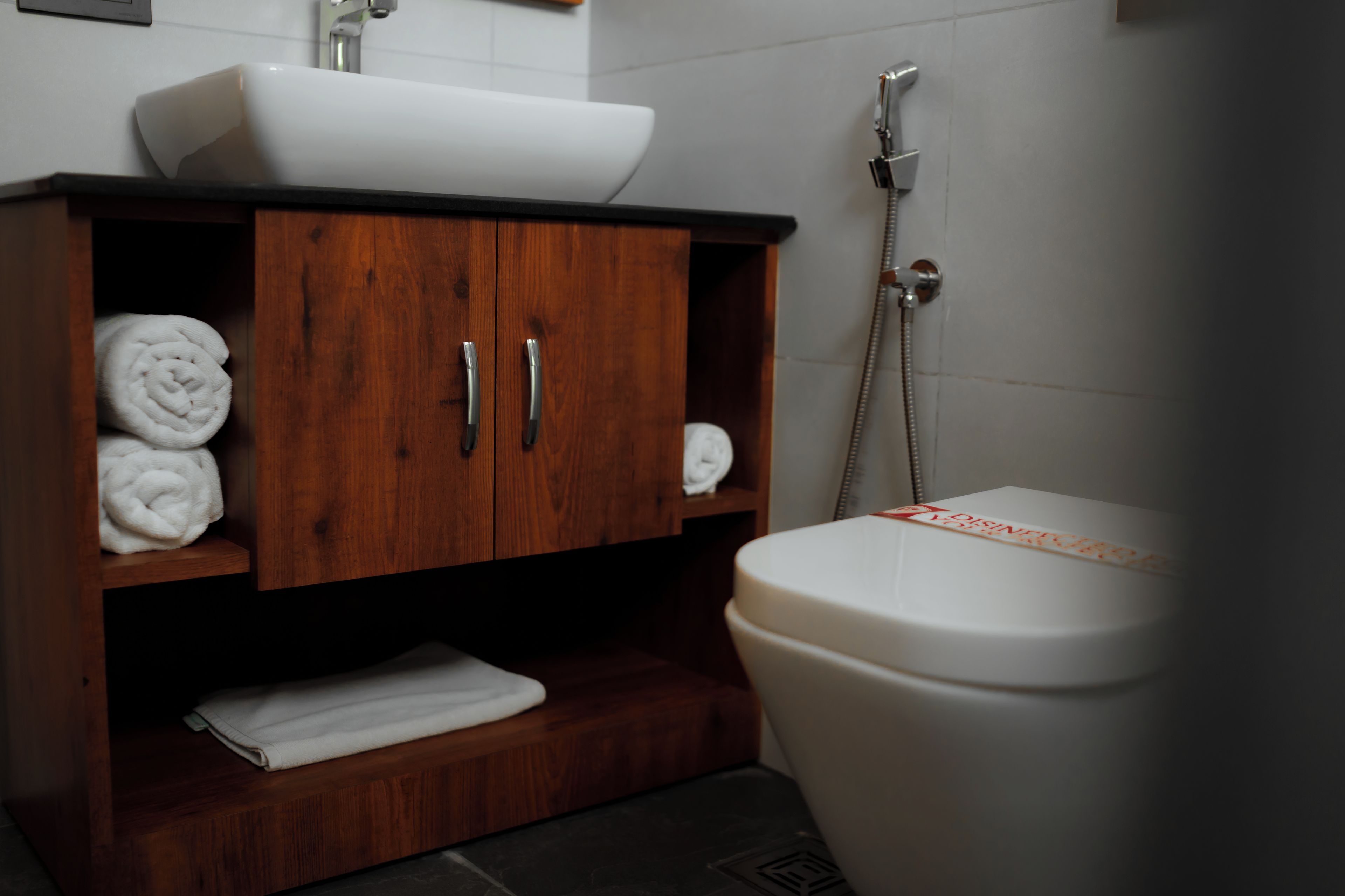 A bathroom with a wooden cabinet, a white sink, and a toilet.