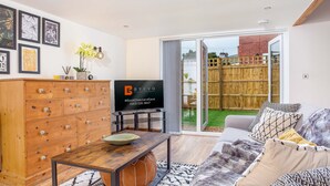 Een woonkamer met een houten kast, een televisie en een bank.