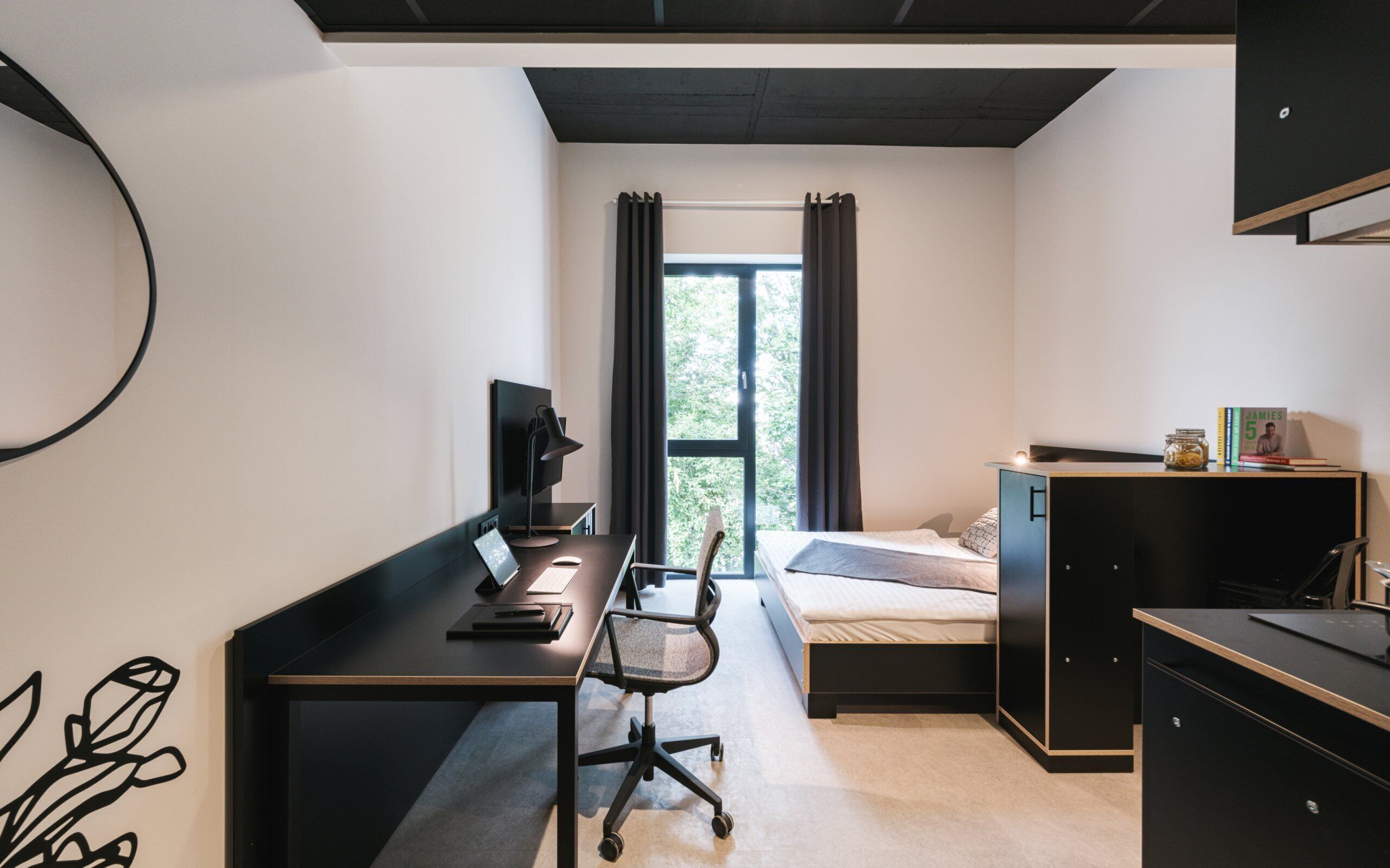 A compact bedroom with a desk, chair, and a bed.