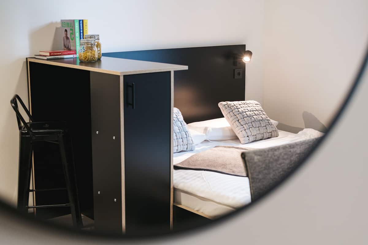 Une petite pièce comprenant un lit, un bureau et une chaise.