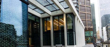 A modern building with large glass windows and a paved walkway.
