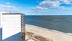 A beachfront hotel with a view of the ocean and a clear sky. - Quay-Beautiful Beach Views in this 2 Bedroom Condo with Indoor Pool! (Ocean City)