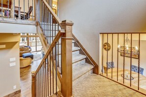 Stairs lead to a dining area with a round table and chairs.
