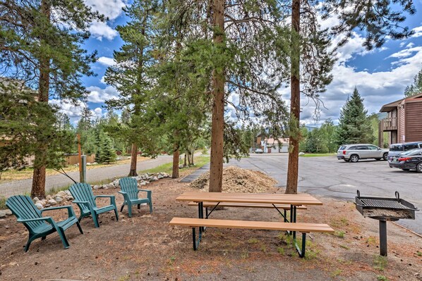 Relax in the serene surroundings of this outdoor seating area, complete with a picnic table and Adirondack chairs.
