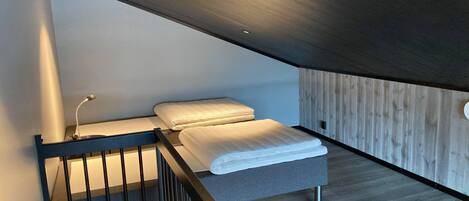 Un dormitorio con una cama, un escritorio y una silla.