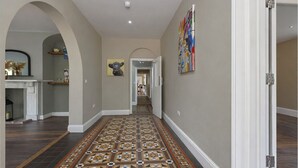A hallway with patterned flooring, a fireplace, and a dining area visible in the background. - Stubbs House, Loddon, sleeps 20, 2 hot tubs (Loddon)