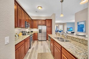 Gourmet Getaway: Our fully furnished kitchen is an open-concept retreat for food enthusiasts, combining functionality with a touch of sophisticated design - Disney near: 3BR Lakeview Balcony Condo (Orlando)