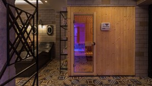 A wooden door leading to a room with patterned floor tiles and a visible sauna. - Dias Hotel & Spa (Dio-Olympos)