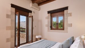 Une chambre avec un lit, une fenêtre et une porte-fenêtre coulissante donnant sur un espace extérieur.
