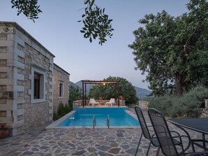 A stone building with a pool, outdoor seating, and a pergola. - Koules Estate-Daphne, with Pool & BBQ, an Agricultural barn for Nature lovers (Rethymno)