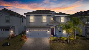 A two-story house with a garage, a driveway, and a well-maintained lawn. - 8BR Villa,Outstanding Game Room,Resort - by Blue Sky Villas (Championsgate)