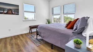 A bedroom with a bed, a bench, a rug, a plant, and a painting on the wall. - Pitch Perfect! Minutes from Canyon Lake! (Canyon Lake)