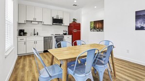 A modern kitchen with white cabinets, a red refrigerator, and a dining table with blue chairs. - Pitch Perfect! Minutes from Canyon Lake! (Canyon Lake)
