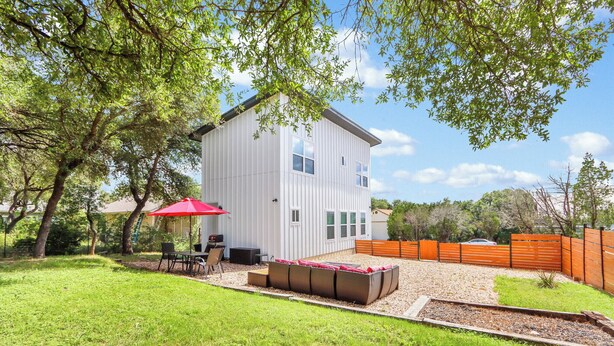 A white two-story house with a patio area, a red umbrella, and a wooden fence. - Pitch Perfect! Minutes from Canyon Lake! (Canyon Lake)