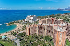 Un resort con varios edificios de gran altura, una playa y un campo de golf.