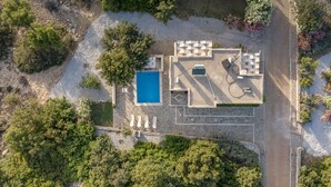 Vista aérea de uma propriedade com piscina, área de estar externa e um pátio de pedra.