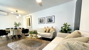 Un salon moderne avec un canapé, une table basse et un coin repas.