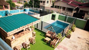 A rooftop pool area with a wooden deck, seating, and a small pool. - Spacious 5 BR Villa with amazing views Bar&Pool | family & large groups | Wi-Fi (Accra)
