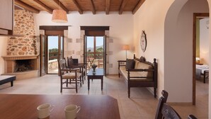 A cozy interior with a stone fireplace, wooden furniture, and a balcony with a view. - Koules Estate-Helianthus, with Pool & BBQ,an Agricultural barn for Nature lovers (Rethymno)