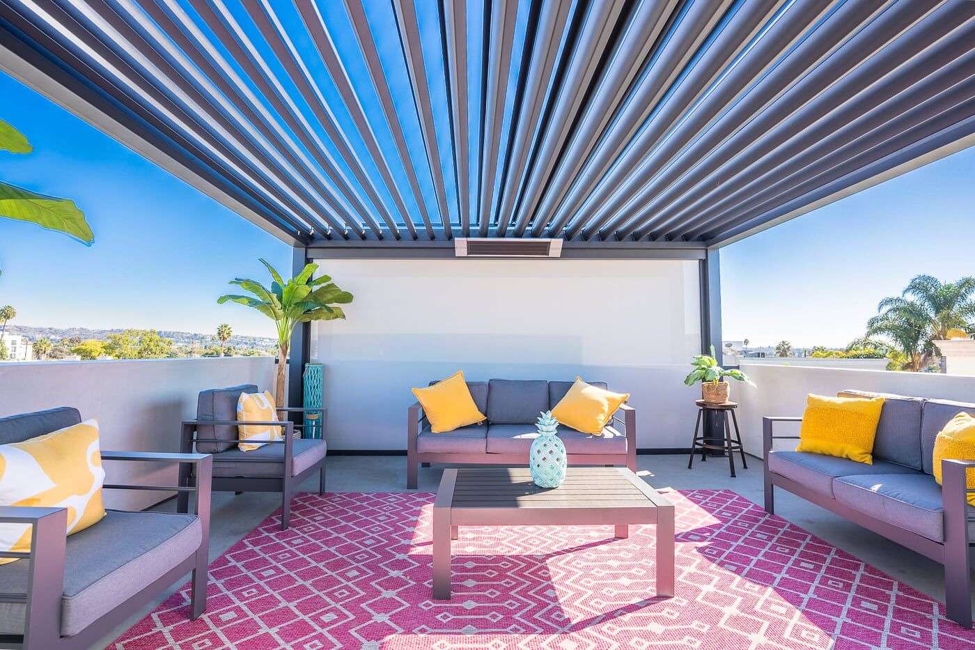 Terraza en la azotea con diseño moderno, que incluye un conjunto de sofás, una mesa de centro y una alfombra estampada.