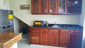 Cozinha com armários de madeira, micro-ondas e fogão.