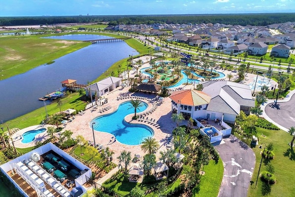 A resort with multiple swimming pools, a large lake, and a golf course.